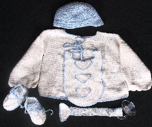 WHITE COTTON WITH BLUE TRIM INCLUDES; BOOTIES, HAT, PACIFIER HOLDER, BIB AND SWEATER.  ALSO AVAILABLE WHITE DIAPER COVER OR STRIPED BOTTOM.