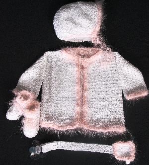 WHITE RAYON WITH PINK FUZZY TRIM.  SET INCLUDES; BOOTIES, HAT, PACIFIER HOLDER AND SWEATER.