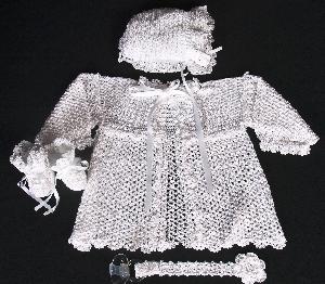 WHITE RAYON EMBELLISHED WITH LOTS OF CROCHETED FLOWERS.  SET INCLUDES; BOOTIES, HAT, PACIFIER HOLDER AND BEAUTIFUL JACKET.