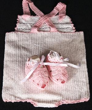 WHITE COTTON SUNSUIT WITH PINK OR BLUE TRIM.  BIB FRONT WITH BACK CROSSING STRAPS.  