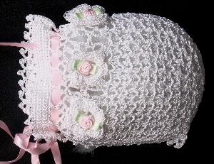 WHITE RAYON HAT WITH WHITE CROCHET FLOWERS WITH TINY PINK ROSEBUD CENTERS WITH GREEN LEAVES.  