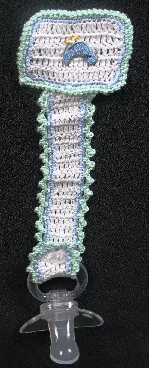 WHITE COTTON PACIFIER HOLDER WITH BLUE AND GREEN TRIM WITH LITTLE BLUE CHICS.   