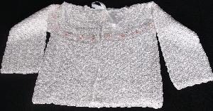 WHITE RAYON TULIP SWEATER HAS PINK TULIPS AROUND THE NECK.   
