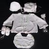WHITE RAYON WITH TINY PINK DAISIES. SET INCLUDES; BOOTIES, CHOICE OF TWO HATS, PACIFIER HOLDER, BIB, SWEATER.