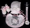WHITE RAYON EMBELISHED WITH WHITE CROCHET FLOWERS WITH PINK ROSEBUD CENTERS. SET INCLUDES BOOTIES, HAT, PACIFIER HOLDER, BIB.