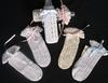 WHITE RAYON BOTTLE COVERS WITH DIFFERENT COLORED RIBBONS.