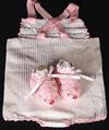 WHITE COTTON SUNSUIT WITH PINK OR BLUE TRIM. BIB FRONT WITH BACK CROSSING STRAPS.