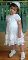 WHITE RAYON DRESS WITH ROWS OF FLOUNCE AND CROCHET ROSETTES.  RIBBONS MAKE THIS ONE OF OUR DRESSES THAT WILL FIT UP TO 6.  WEAR OVER PANTYLOONS TO EXTEND WEARING TIME.   